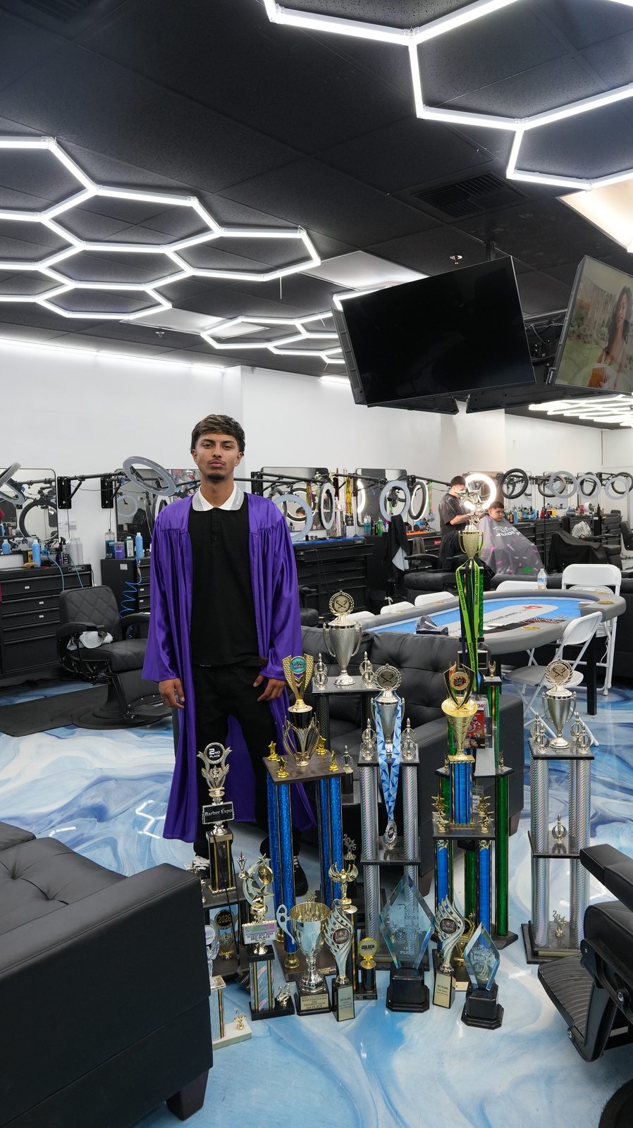 Trophy stack at SoCal Barber Studio — chairs filled, hex ceiling glowing overhead